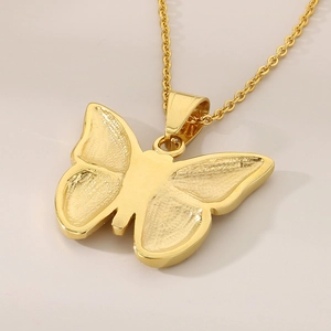 Macro shot of gold butterfly pendant with matte texture and sparkling rhinestone detail
