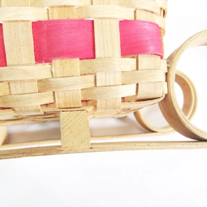 Handgemaakte houten gevlochten opbergmand in sleevorm met rode decoratieve strepen erop
