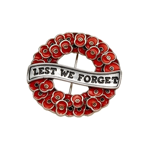 Poppy wreath brooch with red enamel and Lest We Forget engraving on white background