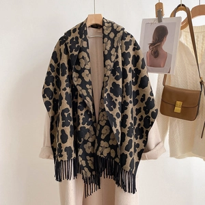 Classic leopard print thick cashmere-like scarf with fringe on a hanger with beige coat