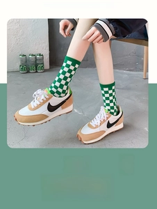 Close-up of green and white checkerboard crew socks worn with vintage sneakers
