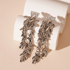 Macro shot of silver metal leaf tassel earrings with sparkling heart-shaped zirconias