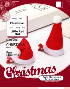 Detailed macro shot of handmade mini Christmas hat hair clips with white plush pom-poms