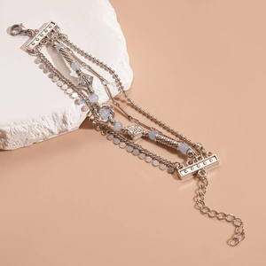 Close-up of bohemian layered silver bracelets with blue beads on stone prop