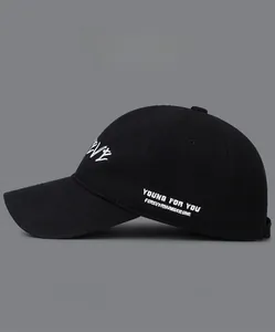 Detail of white embroidery lettering on a black cotton baseball cap with color options