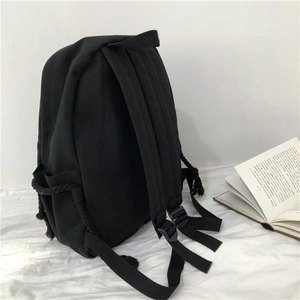 Detail of adjustable black canvas backpack straps with unique side spiral rope design