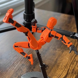 3D-gedruckte Dummy 13 Actionfigur in Orange auf einem schwarzen Displayständer