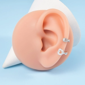 Close-up of pavé zirconia heart ear cuff and drop earring on model display