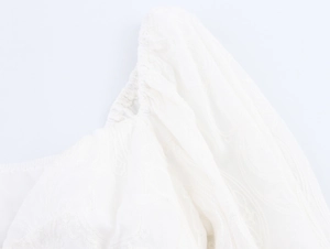 Gros plan du tissu en dentelle blanche avec broderie et texture de manche bouffante