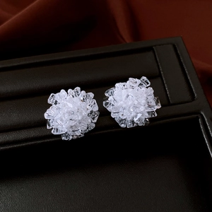 Macro shot of cluster crystal flower earrings on a black leather jewelry box with satin