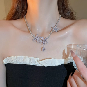Detail of silver floral zircon necklace featuring three crystal blossoms and a teardrop charm