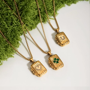 Detail of 18K gold locket necklaces with heart, clover, and fortune horseshoe designs