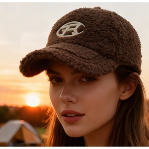 Detail of dark brown faux shearling baseball cap with embroidered R logo in outdoor setting