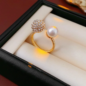 Macro detail of twisted gold ring with pearl and pave crystal ball in jewelry box
