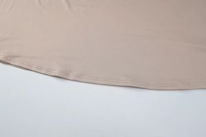Détail du zoom sur l'ourlet à double aiguille de cette robe beige au tissu fluide