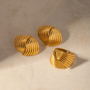 Detailaufnahme von 18k Gold Edelstahlring und Ohrringen im gedrehten Rippendesign