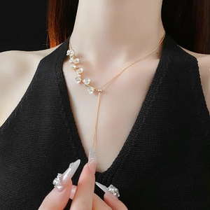 Gold plated Y-shaped necklace featuring delicate white flowers and pearl accents on model