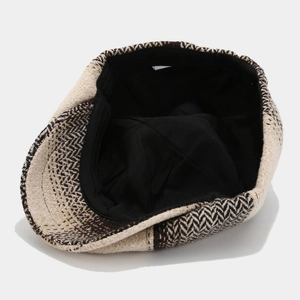 Detail view of beige herringbone newsboy cap showing tweed texture and black inner lining