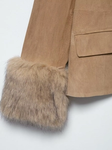 Detail view of suede blazer featuring thick faux fur cuffs and a flap pocket