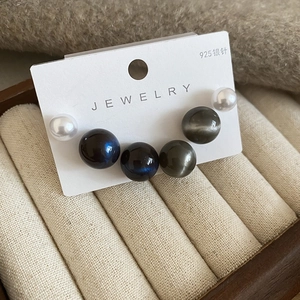 Vue macro détaillée de boucles d'oreilles en perles d'argent 925 sur carte beige
