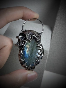 Detailed view of vintage silver dragon claw pendant with glowing labradorite stone
