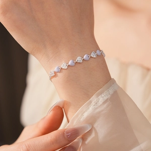 Close-up of lavender enamel heart bracelet with cubic zirconia on a female wrist