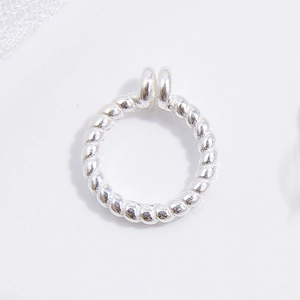 Macro shot of silver twisted metal open jump ring with rope texture for jewelry making