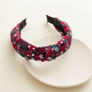 Detail of red Christmas plaid headband with white snowflakes and a top knot design