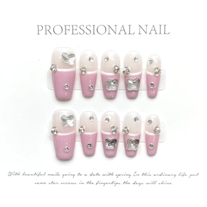 Detail of handmade press-on nails with silver butterflies and sparkling rhinestones