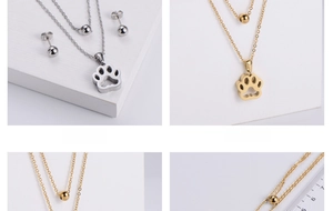 Polished stainless steel jewelry set featuring hollow paw pendant and ball earrings