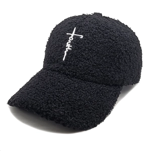 Gros plan sur la broderie croix Faith sur la casquette de baseball noire en polaire teddy