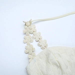 Macro detail of sexy ivory lace dress featuring handcrafted 3D floral embroidery straps