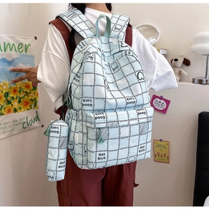 Detailed view of light blue checkered backpack with matching mini pouch and bear graphics