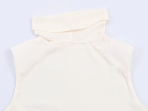 Close-up of the elegant draped turtleneck and shoulder stitching on a beige sleeveless top