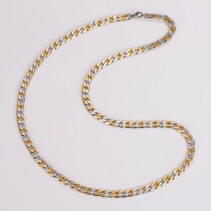Detail view of two-tone gold and silver Cuban link chain with textured surface pattern