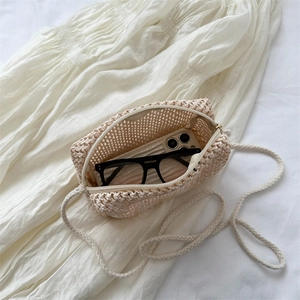 Mini handmade straw woven crossbody bag in beige with phone and glasses for scale
