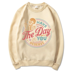 Beige sweatshirt featuring Have The Day You Deserve text and skull hand graphic art
