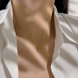 Close-up of 18k gold plated hollow square pendant with zircon on a delicate chain