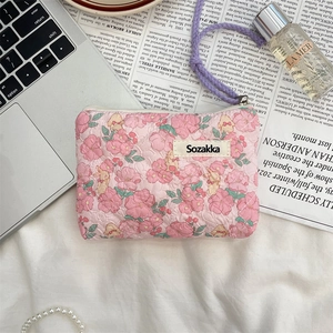 Detailed close-up of a floral bear quilted pouch with a purple handle on a vintage background