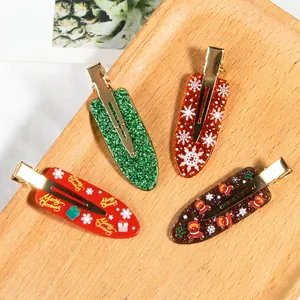 Set of four Christmas hair clips with festive reindeer and snowflake designs on wood