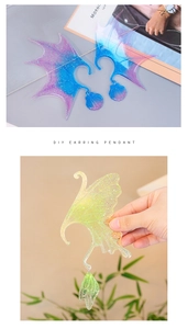 Close-up of gradient glitter resin elf wings and butterfly charms for DIY earrings