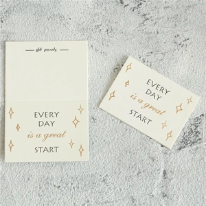 Close-up of minimalist beige greeting card with inspirational quote on stone background