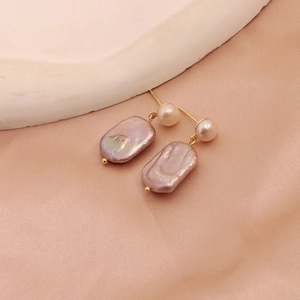 Detail view of mauve baroque pearls and small white round pearls on champagne silk