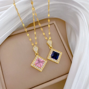 Close-up of pink and blue diamond necklaces on a gift box with white silk fabric