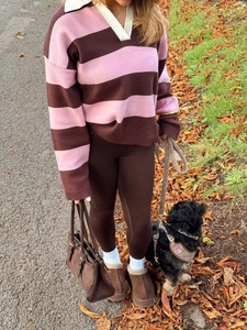 Chic autumn style showing pink and brown striped polo sweater with warm boots in nature