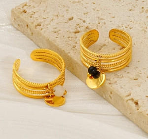 Detail of adjustable gold multilayer ring with black beads and white pearls on stone
