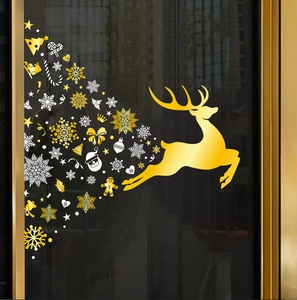 Close-up of golden reindeer and white snowflake static cling stickers on window glass