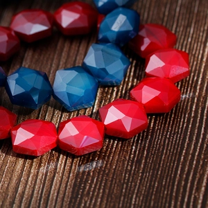 Detailed macro view of colorful hexagonal faceted resin beads on a dark wood background