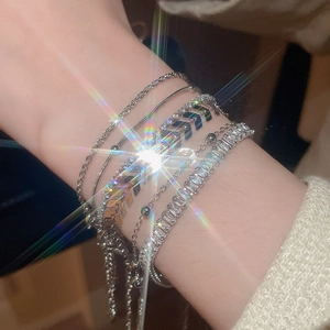 Close-up of stacked silver bracelet set featuring zirconia stones on a female wrist