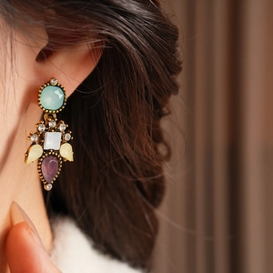 Macro view of vintage round earrings with multicolored crystals on gold metal plating